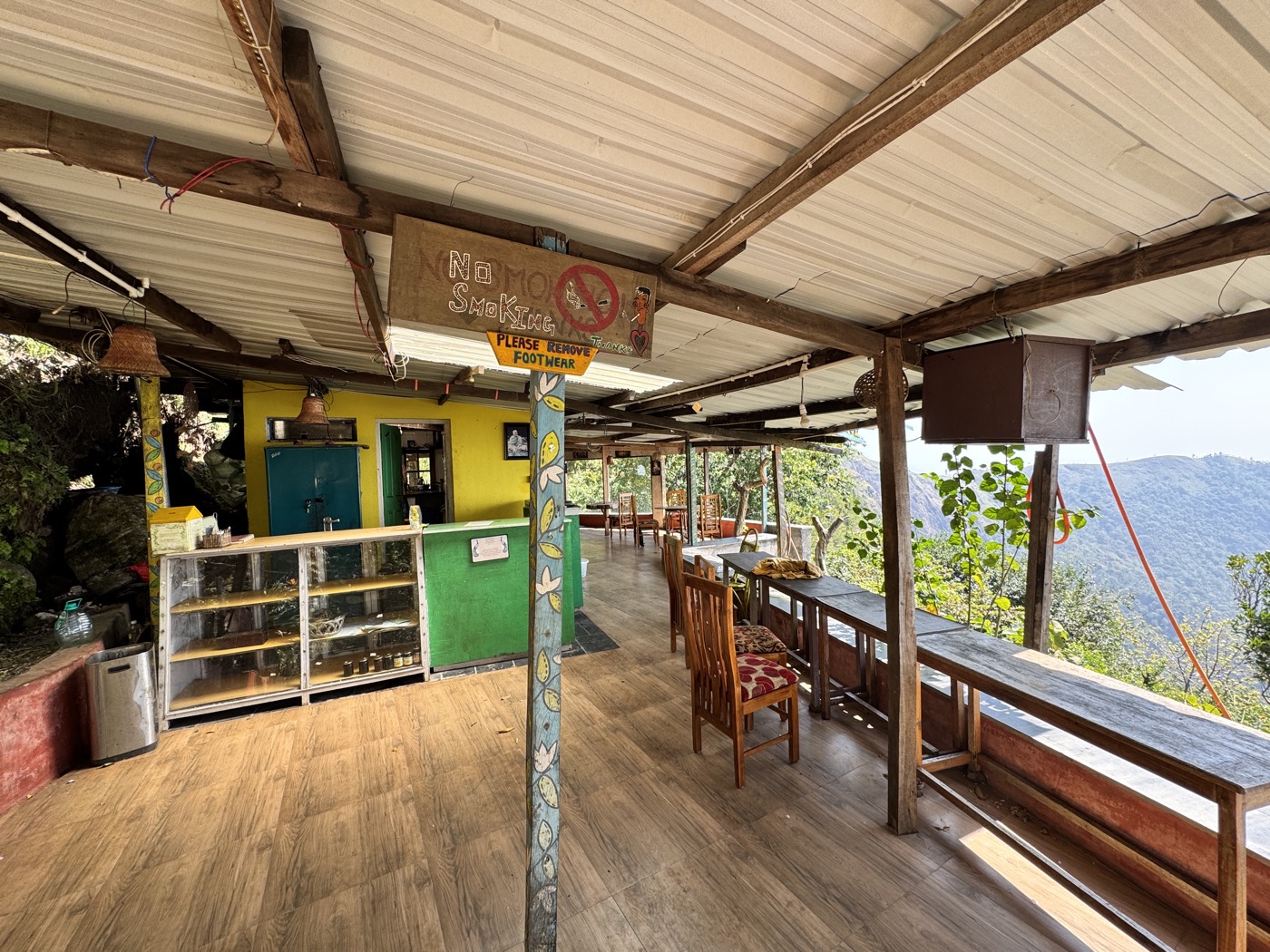 Inside Govinda's Café — the kitchen counter, tables, and the valley beyond